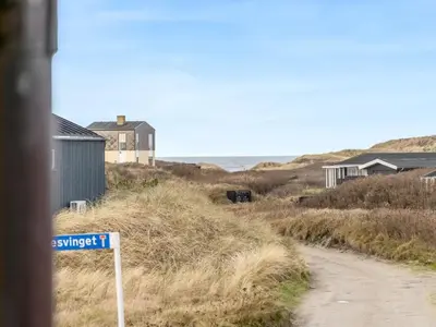 a street sign in front of a dirt road at Holiday Home Åsta - 200m from the sea by Interhome in Saltum