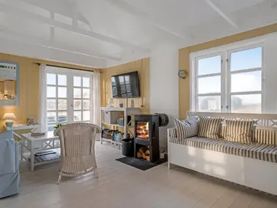 a living room with a couch and a fireplace at Holiday Home Åsta - 200m from the sea by Interhome in Saltum