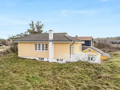 a yellow house sitting on top of a hill at Holiday Home Åsta - 200m from the sea by Interhome in Saltum