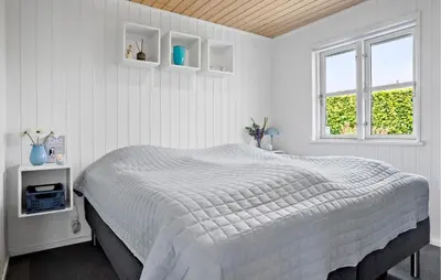a white bedroom with a bed and two windows at 2 Bedroom Cozy Home In Roslev in Roslev