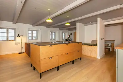 a large room with a wooden dresser and a bed at Historic Ferry House By Limfjorden In Sillerslev in Øster Assels