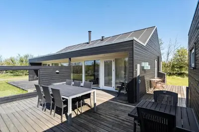 a wooden deck with a table and chairs on it at JB374-Brovst-Kronvildtvej-222 in Tranum Strand