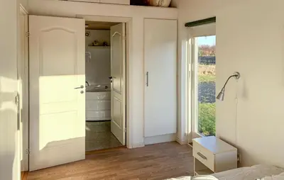 a bedroom with a door leading to a bathroom at 3 Bedroom Amazing Home In Brovst in Brovst