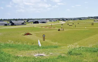 a large field of grass with buildings in the background at 3 Bedroom Amazing Home In Brovst in Brovst