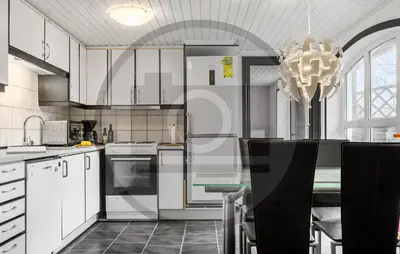 a kitchen with white cabinets and a table and a chandelier at 2 Bedroom Pet Friendly Home In Øster Assels in Øster Assels