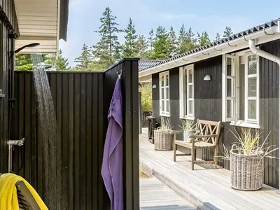 a deck with a black fence and a house at 4 star holiday home in Blokhus in Blokhus