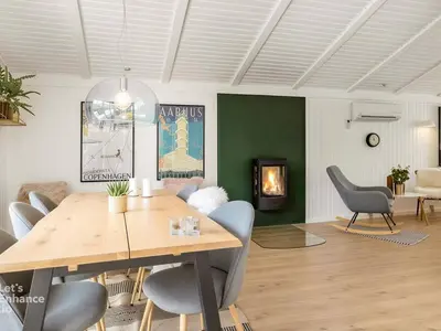 a dining room with a table and chairs and a fireplace at 4 star holiday home in Blokhus in Blokhus