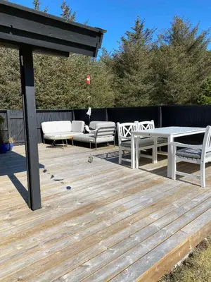 a wooden deck with a table and chairs on it at Peaceful Base Near Beach And Nature in Saltum