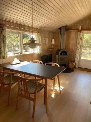 a dining room with a table and chairs and a stove at Peaceful Base Near Beach And Nature in Saltum