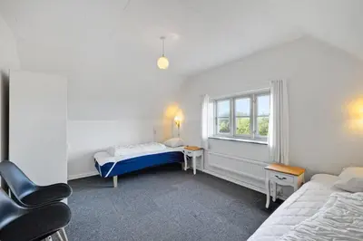 a small room with two beds and a window at Feddet, Jørgen's Feriehus in Lemvig