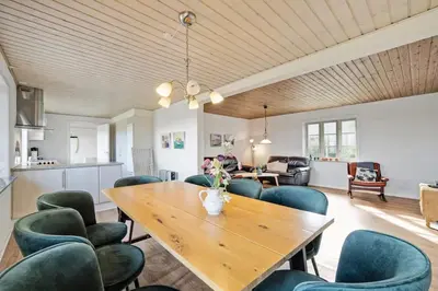 a living room with a wooden table and chairs at Feddet, Jørgen's Feriehus in Lemvig