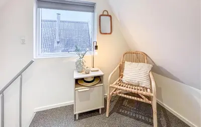 a wicker chair in a stair room with a window at Awesome Home In Farsø With Wifi in Farsø