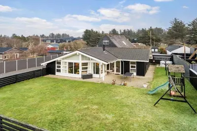 a house with a large yard with a playground at BL1143-Blokhus-Engen-1 in Blokhus