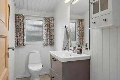 a bathroom with a toilet and a sink and a window at 1371-Thisted-Havtornvej-1 in Nørre Vorupør