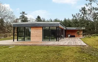 a small house with a wooden deck in a field at Nice Home In Skals With Wifi in Skals