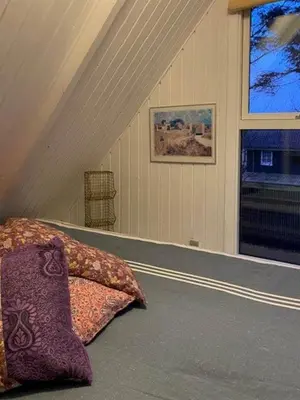 a bed with pillows and a window in a room at Cosy Little Wooden House On Natural Grounds in Vestervig