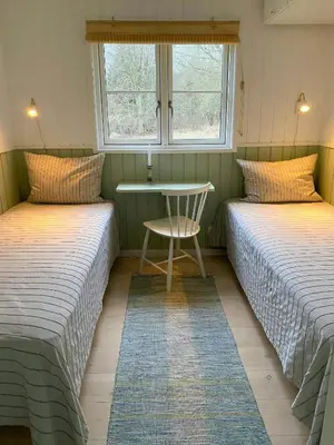 two beds in a room with a table and a window at Cozy Holiday Home With Fjord Views On Fur in Fur