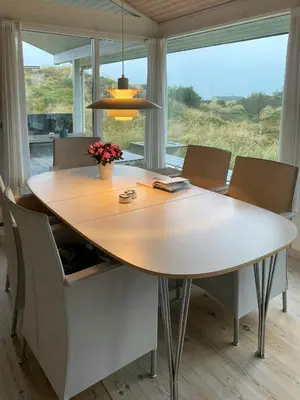 a dining room table with chairs and a large window at Summer House With Views Over Jammerbugt in Saltum