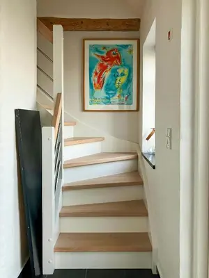 a staircase in a house with a painting on the wall at Restored Fisherman's House On Cliff In Thy in Hanstholm
