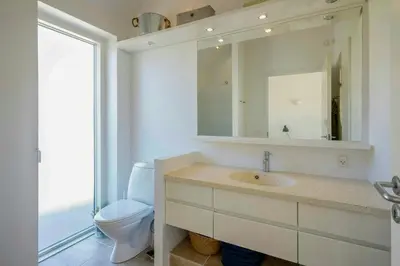 a bathroom with a toilet and a sink and a mirror at Thatched House At First Dune Row In Blokhus in Blokhus