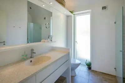 a bathroom with a sink and a toilet at Thatched House At First Dune Row In Blokhus in Blokhus