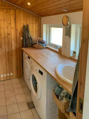 a bathroom with a washing machine and a sink at Holiday Home By The North Sea Dunes In Rødhus in Pandrup