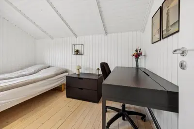 a bedroom with a desk and a bed and a table at BL1155-Blokhus-Berberisvej-74 in Blokhus