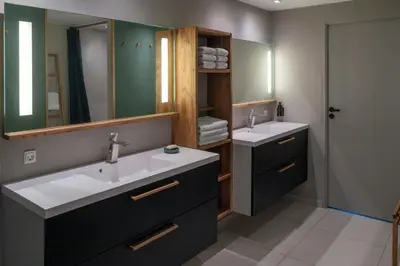 a bathroom with two sinks and a mirror at Historic Farm And Surf Shack At Cold Hawaii in Thisted