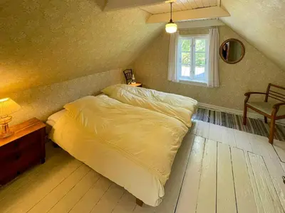 a bed in a bedroom with a window at Historic House From 1887 Near Nationalpark Thy