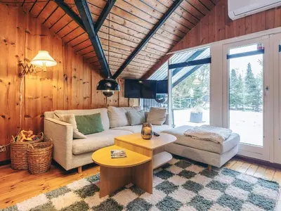 a living room with a couch and a table at Holiday home near fishing lake in Fjerritslev