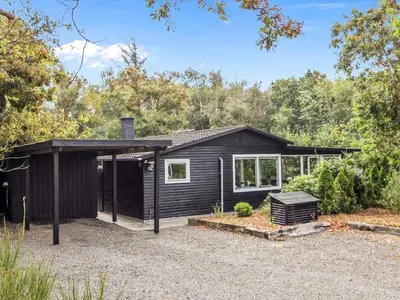 a black house with a garage at 6 person holiday home in Løgstør in Løgstør