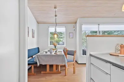 a kitchen and dining room with a table and chairs at BL1154-Blokhus-Kornblomstvej-22 in Blokhus