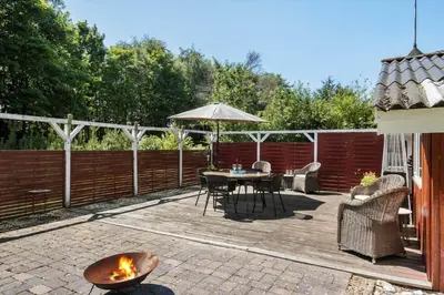 a patio with a table and an umbrella at JB381-Fjerritslev-Ahornvej-65