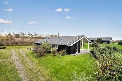 a house in the middle of a field with a dirt road at JB406-Fjerritslev-Aspevej-68 in Fjerritslev