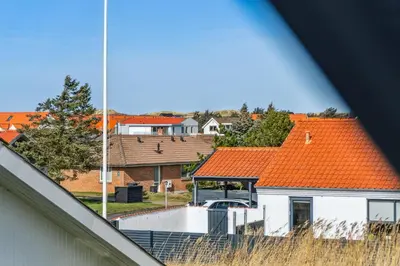 a house with an orange roof with a balcony at Holstvej 21 in Blokhus
