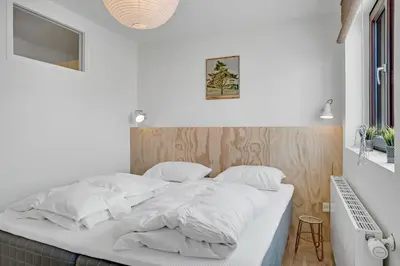 a white bed with white sheets and pillows at Søndergade 21, Lejl 3 in Løkken