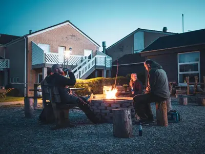 a group of people sitting around a fire pit at Feriecenter Slettestrand in Fjerritslev