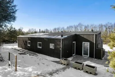 a black house with two benches in the snow at JB376-Fjerritslev-Egevej-14