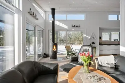 a living room with black leather furniture and a fireplace at JB376-Fjerritslev-Egevej-14