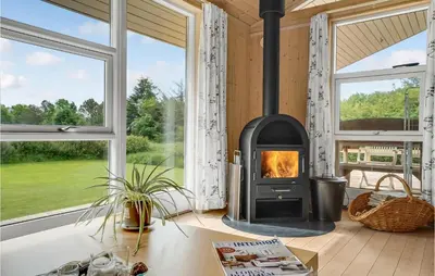 a fireplace in a living room with windows at Holiday Home Hurup Thy With A Fireplace 06 in Heltborg