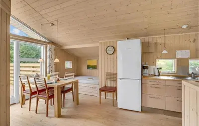 a kitchen and dining room with a table and a refrigerator at Holiday Home Hurup Thy With A Fireplace 06 in Heltborg