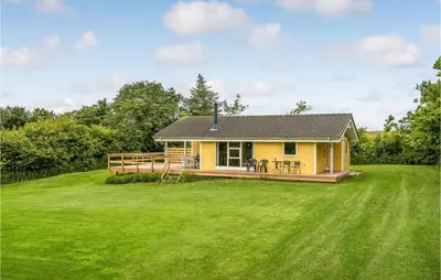 a small yellow house with a large yard at Holiday Home Hurup Thy With A Fireplace 06 in Heltborg