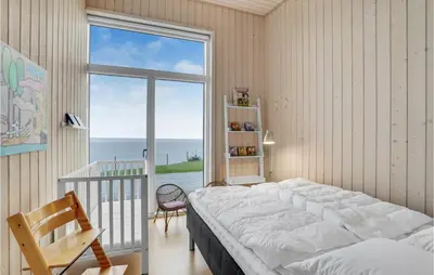 a bedroom with a large bed and a large window at Holiday Home Roslev With A Fireplace 01 in Roslev
