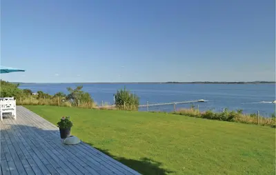 a patio with a bench and a view of the water at Holiday Home Roslev With A Fireplace 01 in Roslev