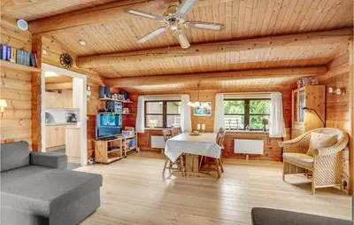 a living room with a table and a ceiling fan at Nørklit in Frøstrup