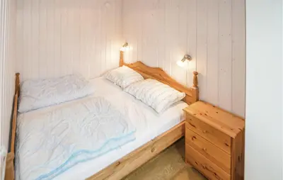 a bedroom with a large bed with a wooden frame at Holiday Home Brovst With A Fireplace 03 in Brovst