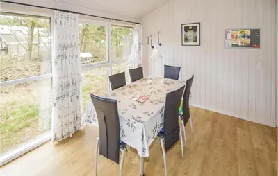 a dining room with a table and chairs and a window at Holiday Home Brovst With A Fireplace 03 in Brovst