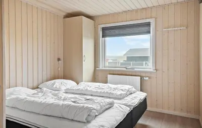 two beds in a room with a window at Cozy Home In Harboøre With Kitchen in Harboør
