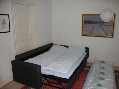 a bed sitting in a room next to a door at Klosterpensionen Annex in Viborg