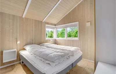 a large bed in a room with two windows at Holiday Home Vemb With Fireplace 07 in Vemb